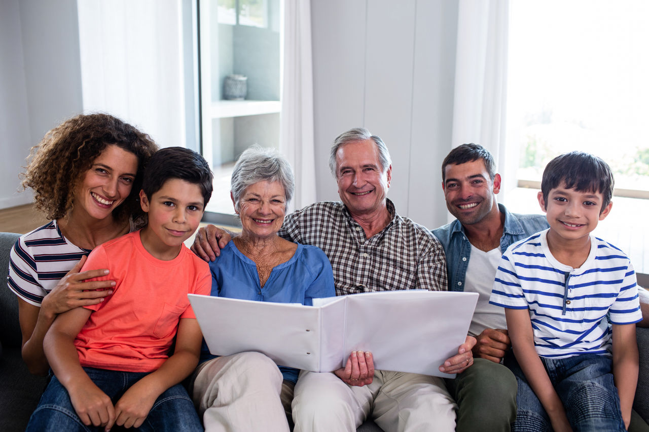 Family sitting on the couch looking through an photo album